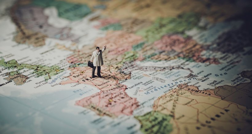 figurine standing on a map of europe, tilt-shift perspective