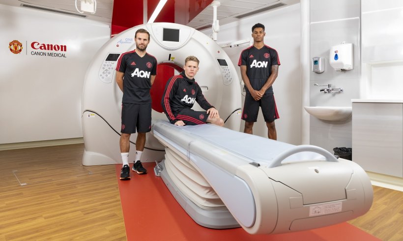 3 soccer players standing around and sitting on volume ct device