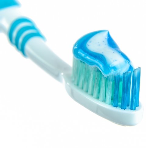 blue and white toothpaste on toothbrush