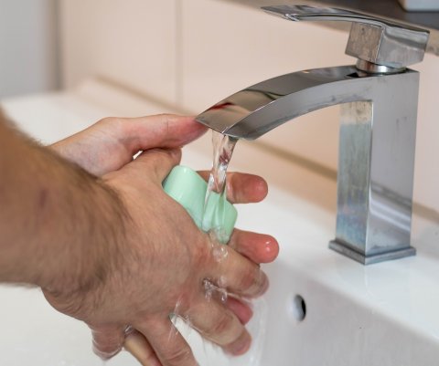 person washing hands with bar of soap