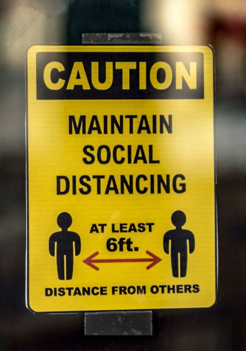 yellow and black social distancing sign