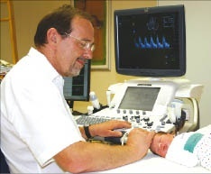 Prof. Deeg beim schallen eines Neugeborenen durch die Fontanellen