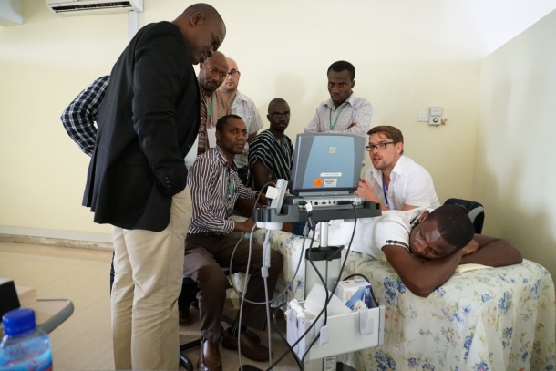 Dr. Alexander Dinse (far right) encourages delegates to try ultrasound scanning...