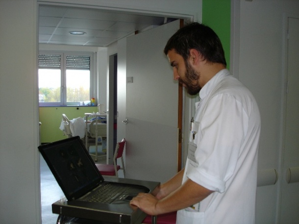 A doctor checks a patients record before a visit within the hospital