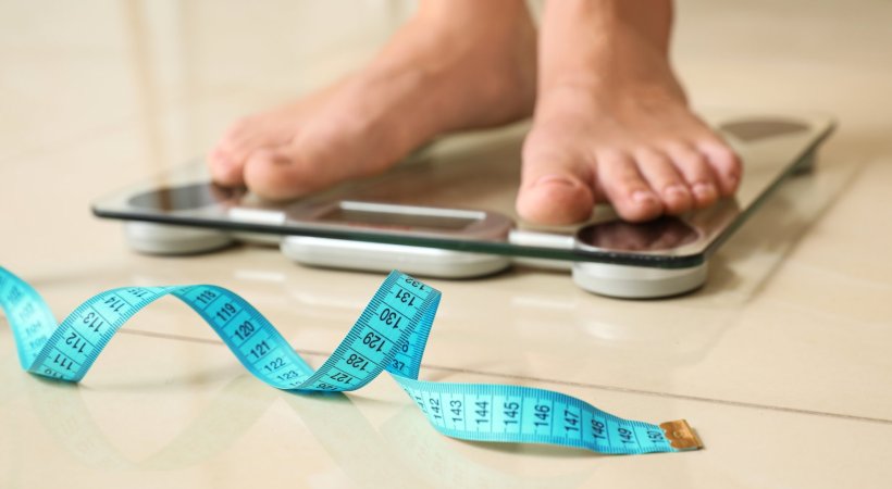 feet of woman measuring her weight on personal scales