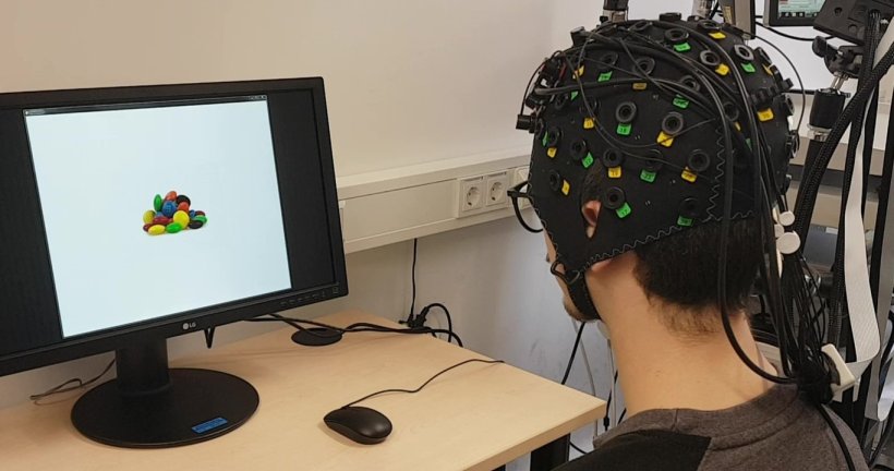 Aufbau des fNIRS-Neurofeedback: Auf dem Monitor sehen die Teilnehmenden Bilder...