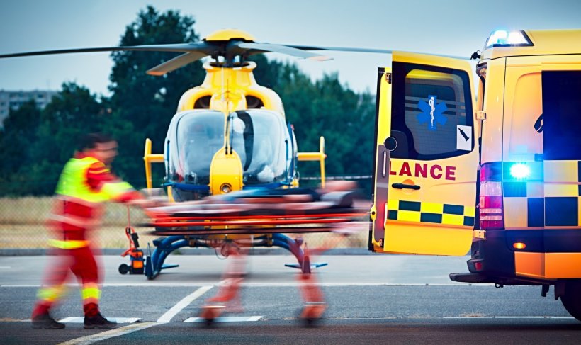 emergency paramedics carying patient from ambulance to helicopter
