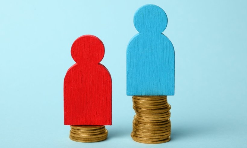 red and blue wooden play figurines on coin stacks, illustrating financial...