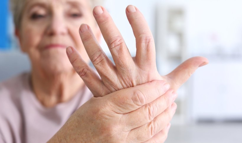 elderly woman holding her hand with arthritis pain