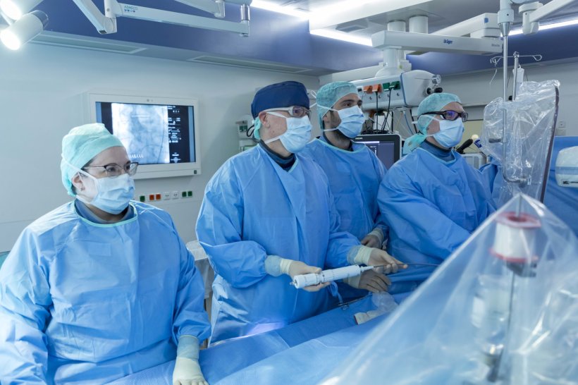 Interdisciplinary cardio team in the hybrid OR performing catheter-based...