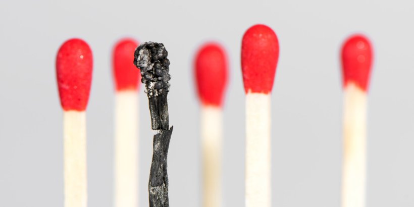 row of matches, with one burnt match in foreground, symbol for burnout