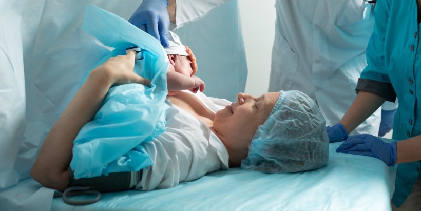 mother holding her newborn baby after giving birth in hospital