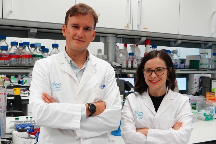 Joaquin Mateo and Irene Casanova standing in a medical laboratory, with arms...