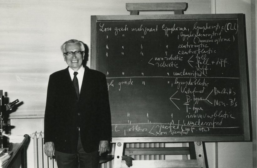 Historisches Schwarz-Weiß-Foto von Prof. Karl Lennert neben einer Schultafel,...