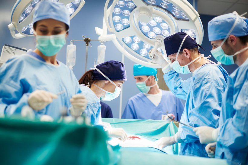 A group of surgeons in the operating room of a hospital; their attention is...