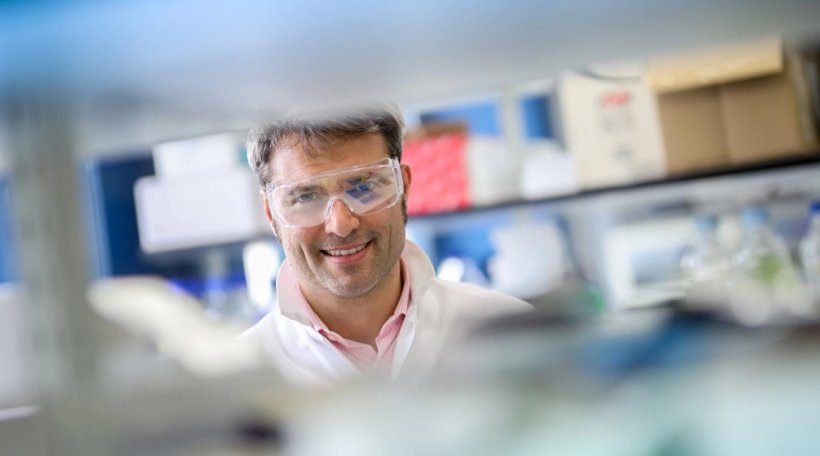 Photo of Professor Alessio Ciulli standing in a laboratory; the upper and lower...