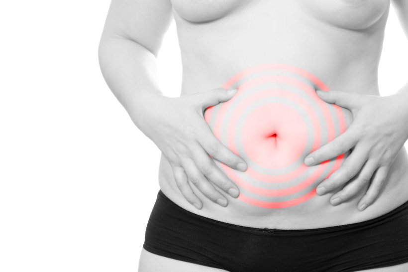 Young woman put her hand on her stomach because she has irritable bowel syndrome