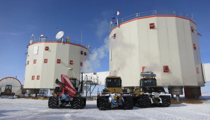 Three heavy vehicles in front of a polar research station