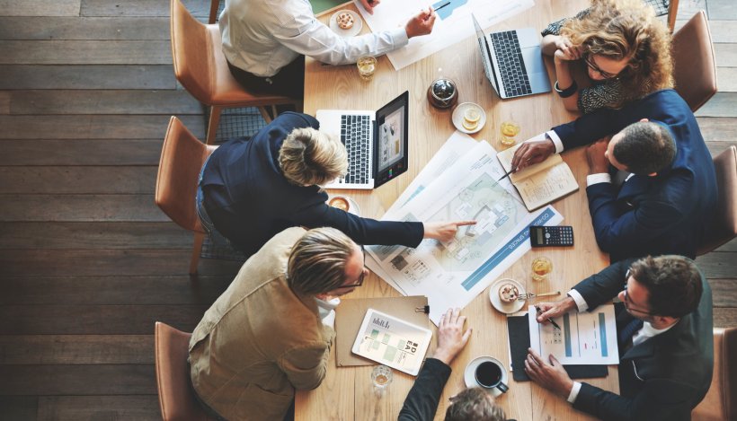 Business people discussing at a conference table, shown from an overhead...