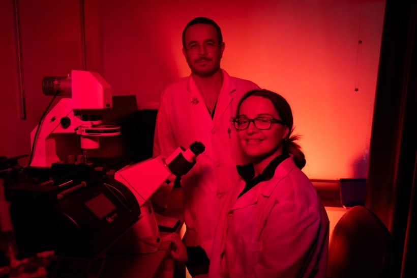 Two scientists sitting in a red-lit laboratory