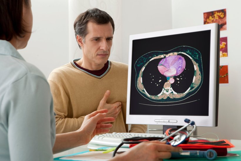 A female doctor talking to her patient, discussing heart health. On a computer...