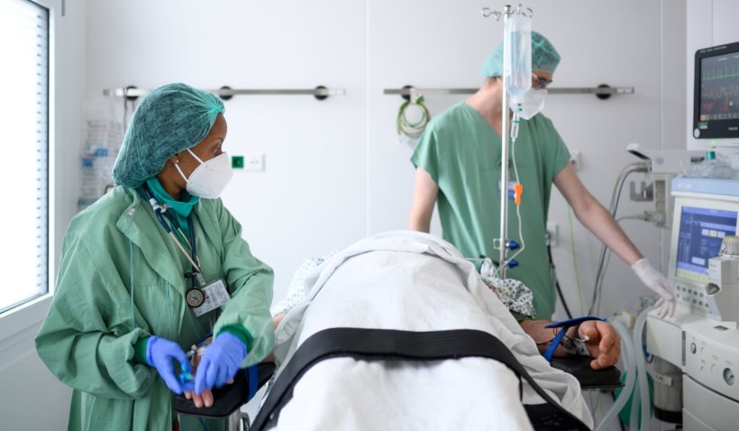 Zwei Intensivmediziner stehen an einem Patientenbett auf der Intensivstation...