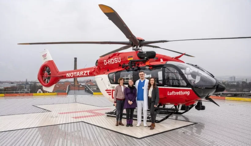 Fünf Frauen und Männer stehen auf dem Helikopterlandeplatz eines...