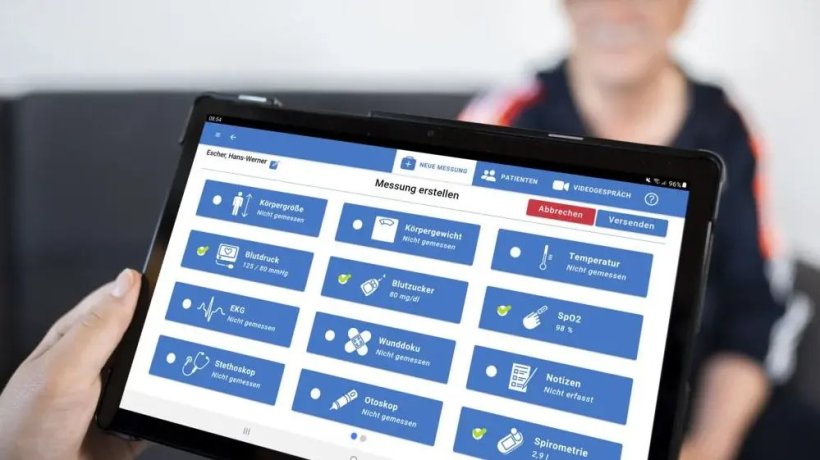 Ein Tablet-Computer mit Telemedizin-Icons wird von einer Hand gehalten....