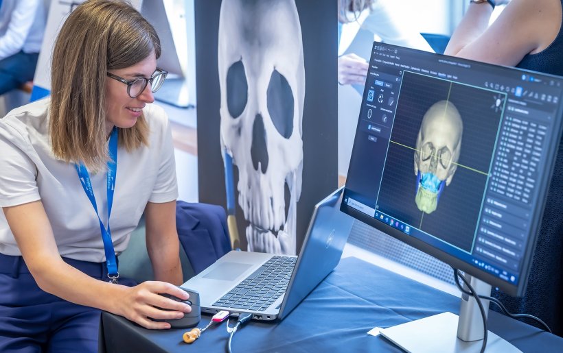 A young woman is using a 3D visualisation software on a laptop to view a 3D...