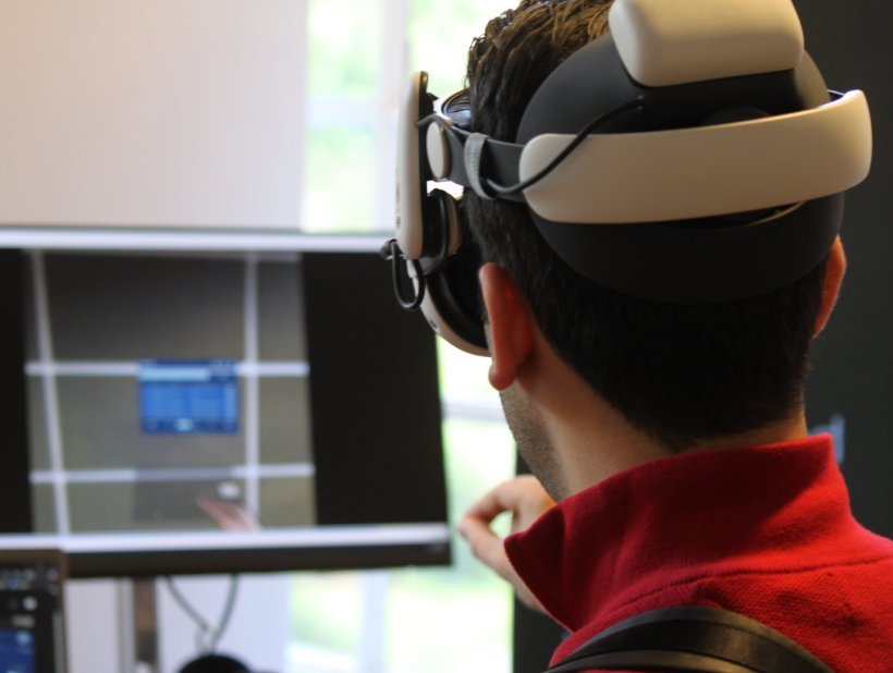 A man wearing a virtual reality headset is interacting with pinched fingers....