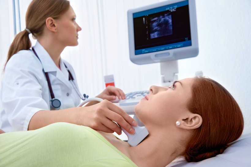 Eine Ärztin untersucht den Hals ihrer Patientin mit einer Ultraschall-Sonde....