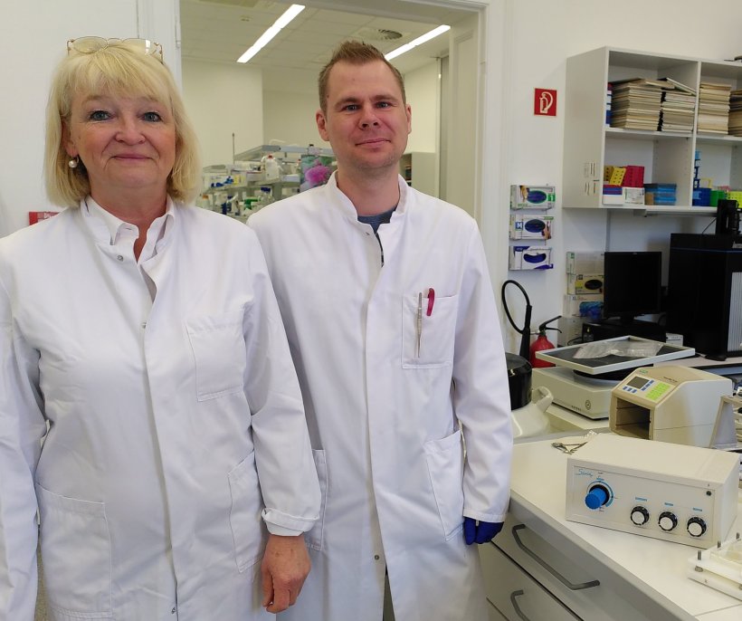 Zwei Wissenschaftler stehen im Labor neben Versuchsgeräten