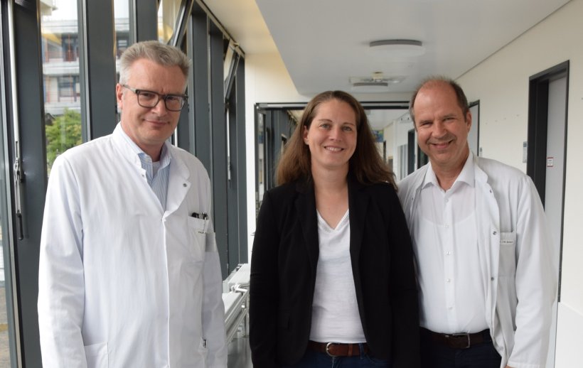 Drei Forschende der Universität Marburg stehen gemeinsam im Labor und...