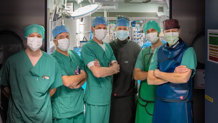 Sechs Chirurgen posieren für ein Gruppenfoto im OP