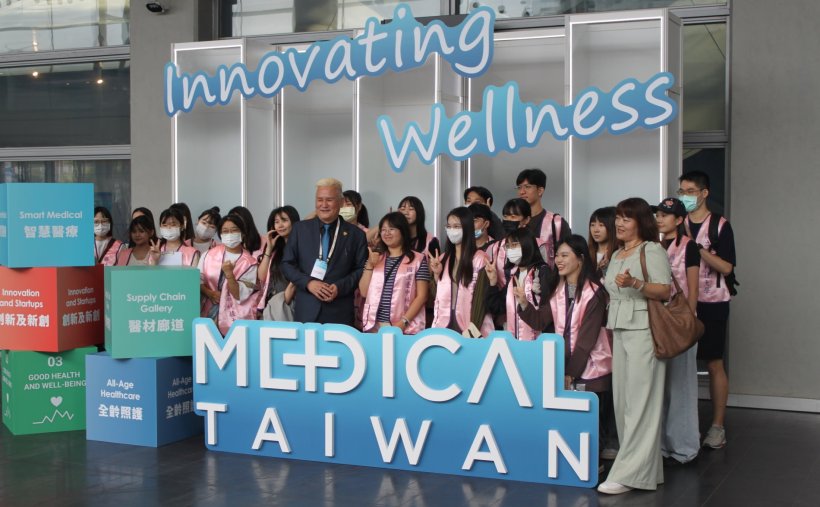 A group of people posing for a photo at the Medical Taiwan expo logo
