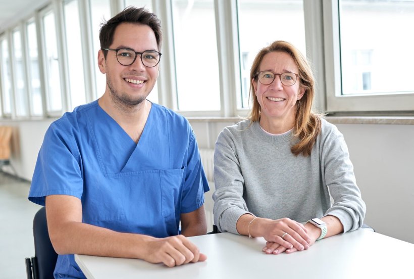 Dr. Justin Ferdinandus und Dr. Karolin Behringer sitzen nebeneinander an einem...