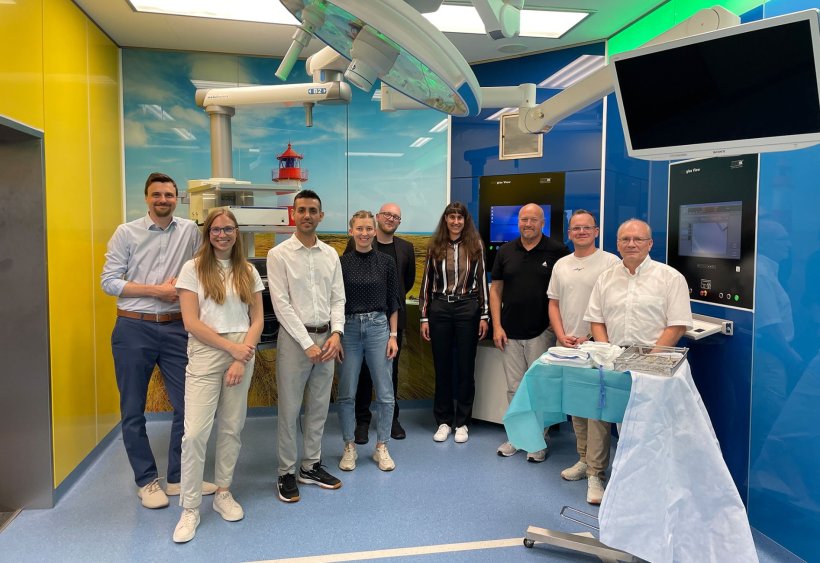 Gruppenfoto mit neun Personen in einem Operationssaal