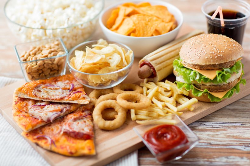 Eine Auswahl hochverarbeiteter Lebensmittel wie Fertigpizza, Burger, Pommes...