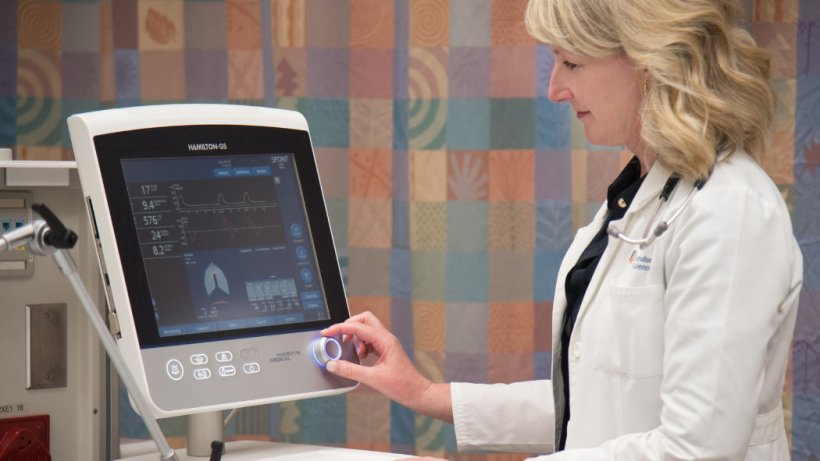 A female doctor operating a medical ventilation machine