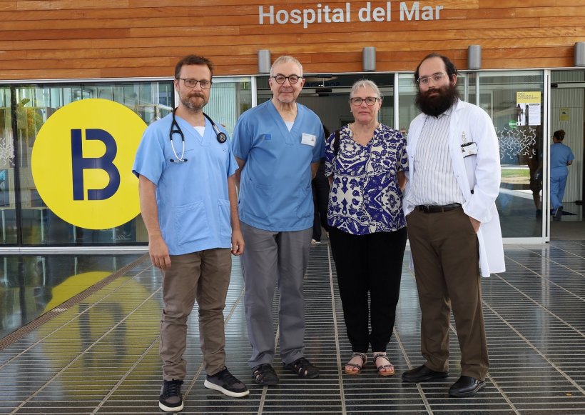 Four persons lined up for a tram photo in front of the Hospital del Mar entrance