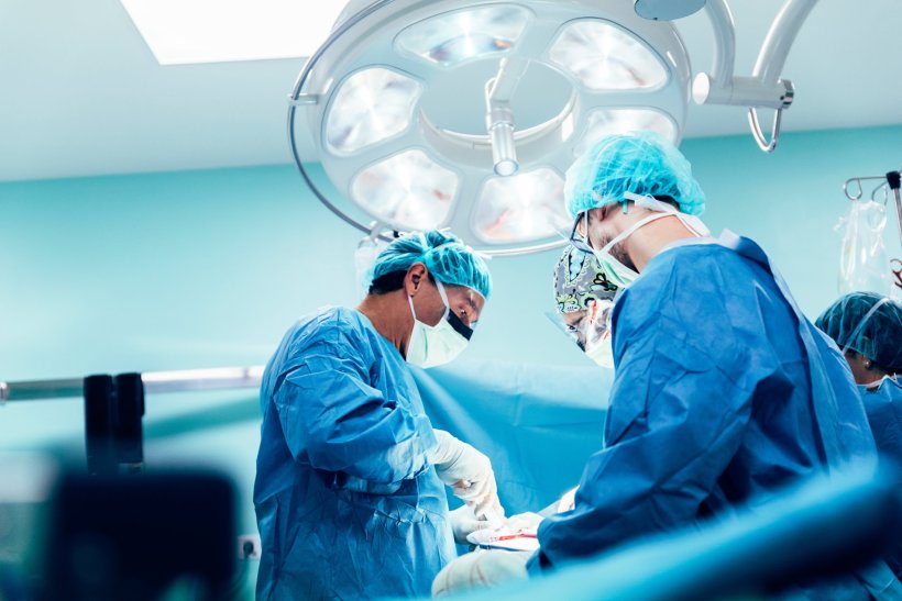 A team of surgeons performing surgery in the operating theatre of a hospital