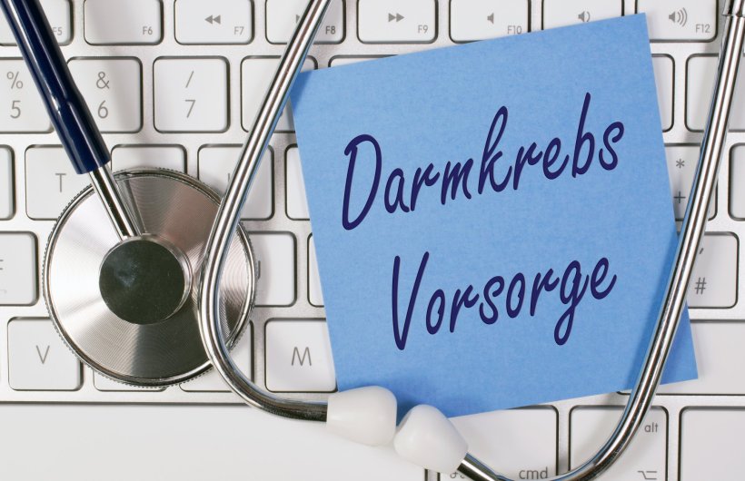Eine blaue Haftnotiz mit der Aufschrift Darmkrebs Vorsorge liegt auf einer...