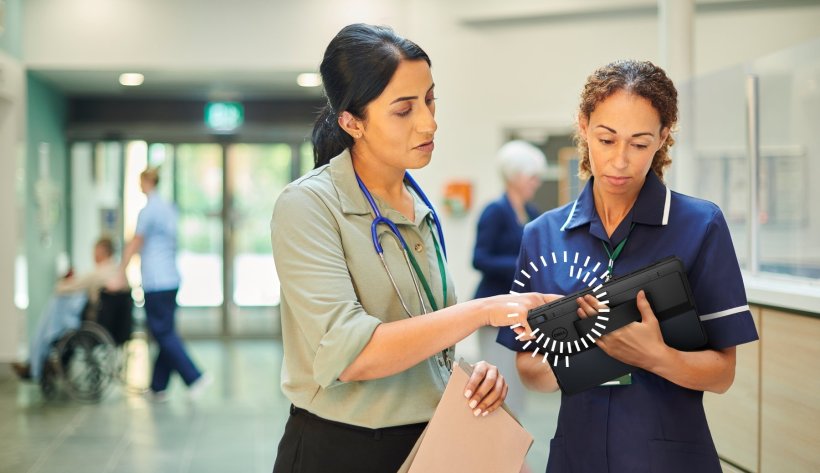 Zwei Ärztinnen besprechen im Eingangsbereich eines Krankenhauses einen...