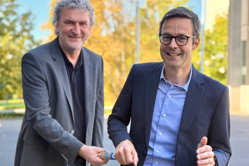 Professor Markus Gosch reicht einen Staffelstab an Professor Michael Denkinger