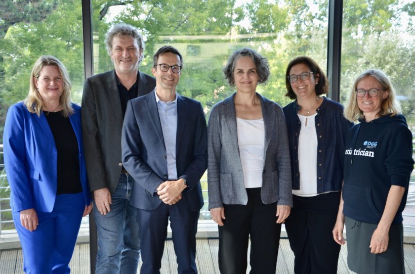 Sechs Menschen stehen für ein Gruppenfoto nebeneinander