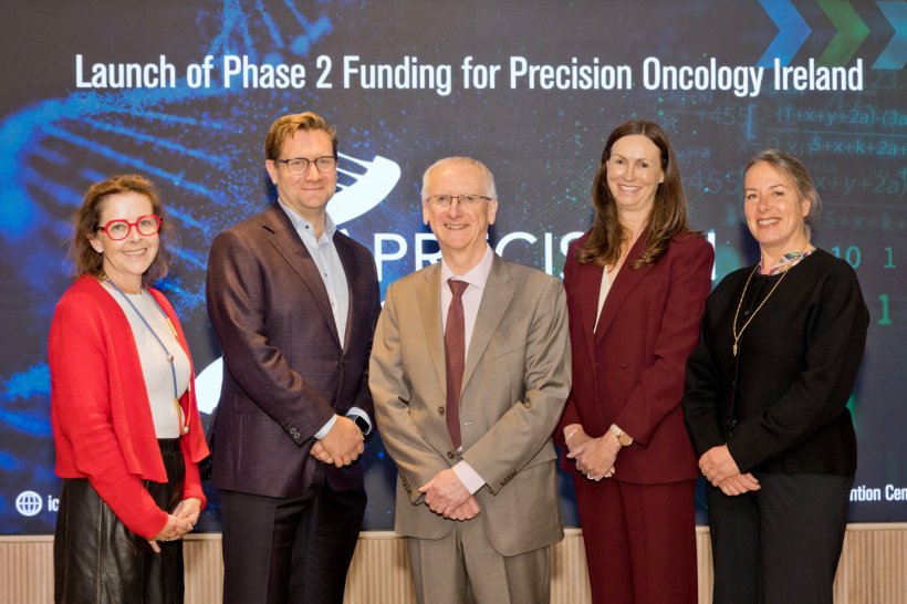 A group photo of five people, with a caption above reading Launch of Phase 2...