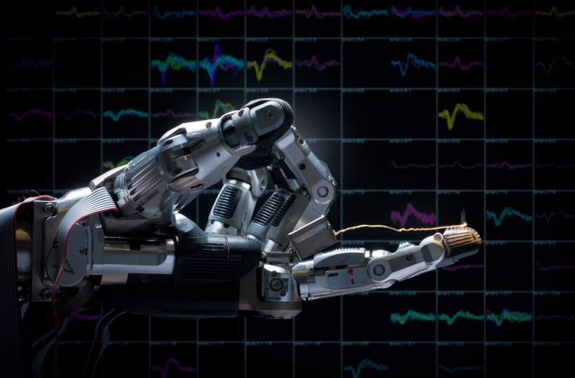 Eine robotische Hand mit ausgestrecktem Zeigefinger vor ein em dunklen...