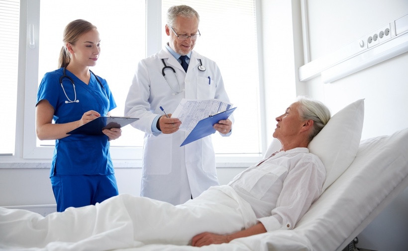 doctor and nurse visiting senior woman at hospital