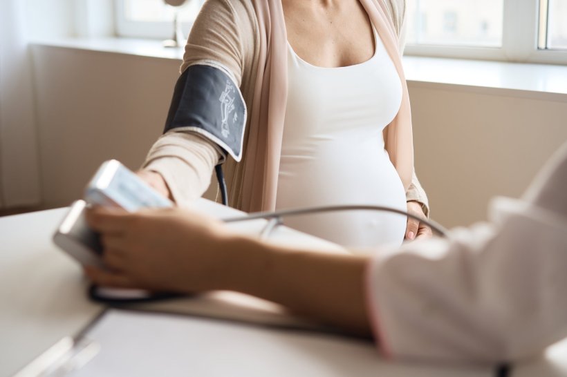A doctor is measuring the blood pressure of her pregnant patient