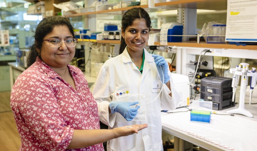 Two women sanding in a laboratory setting